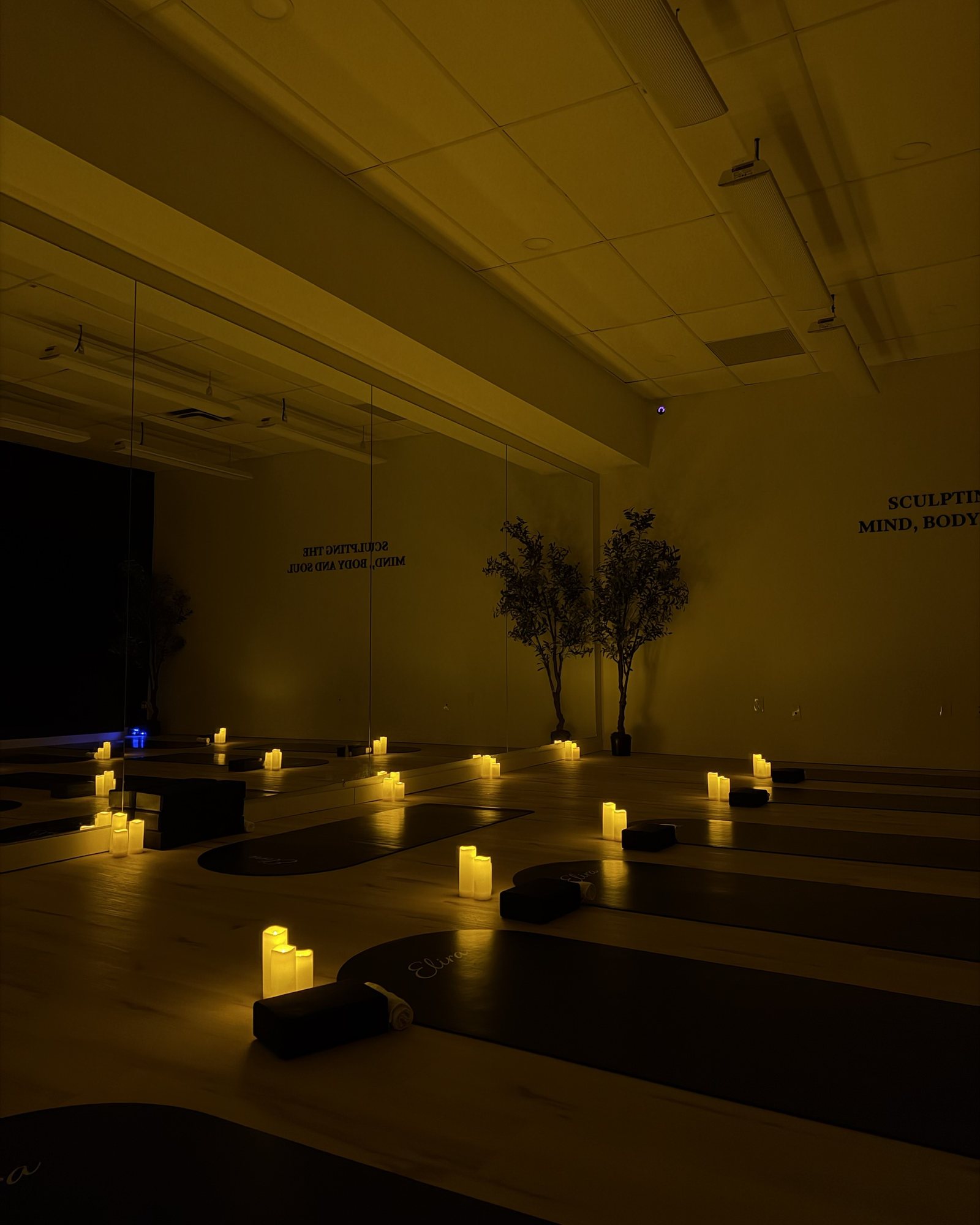 The infrared heated mat studio at Elira Pilates, lit by candlelight